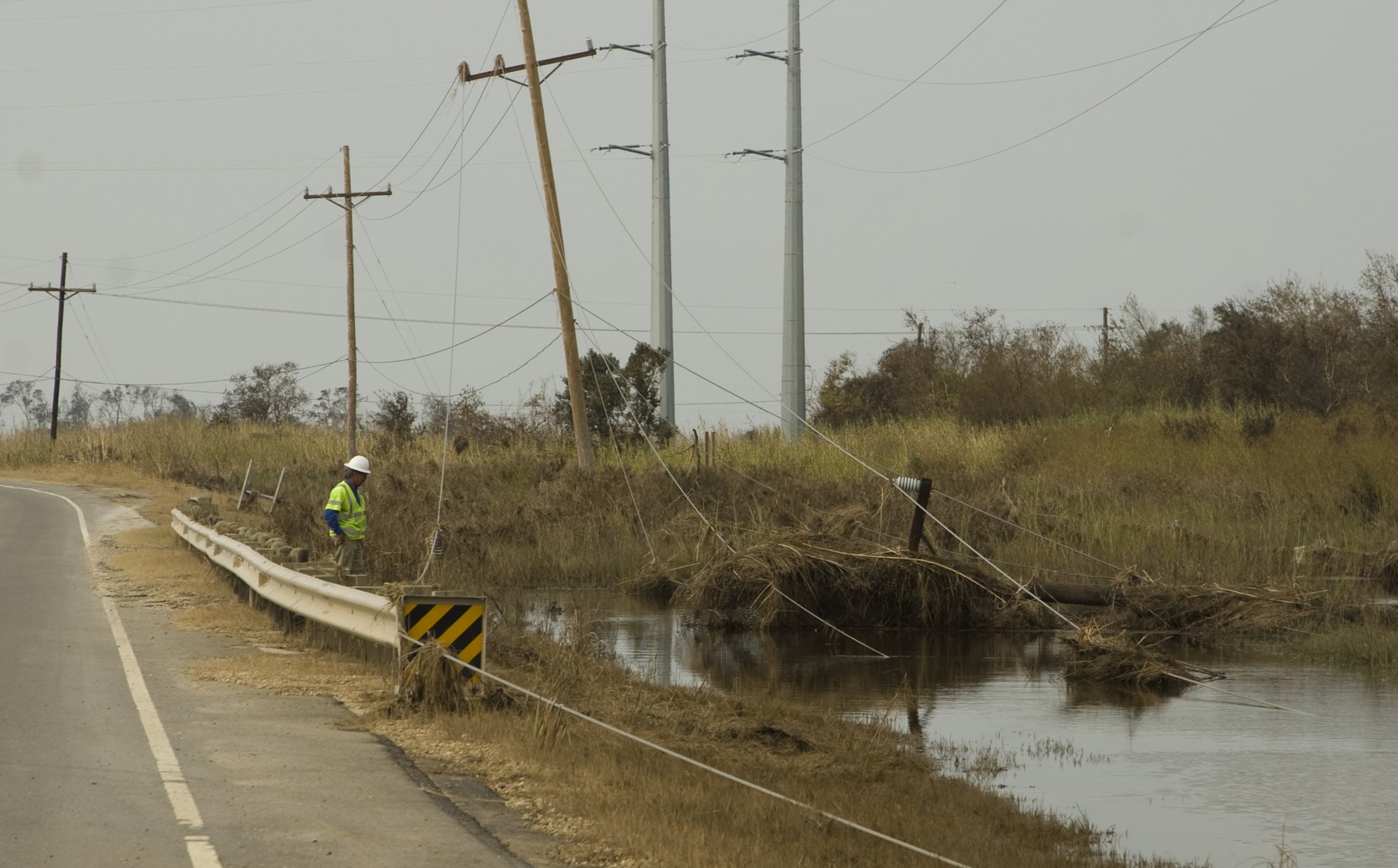 Lineman inspecting overhead distribution lines after a storm