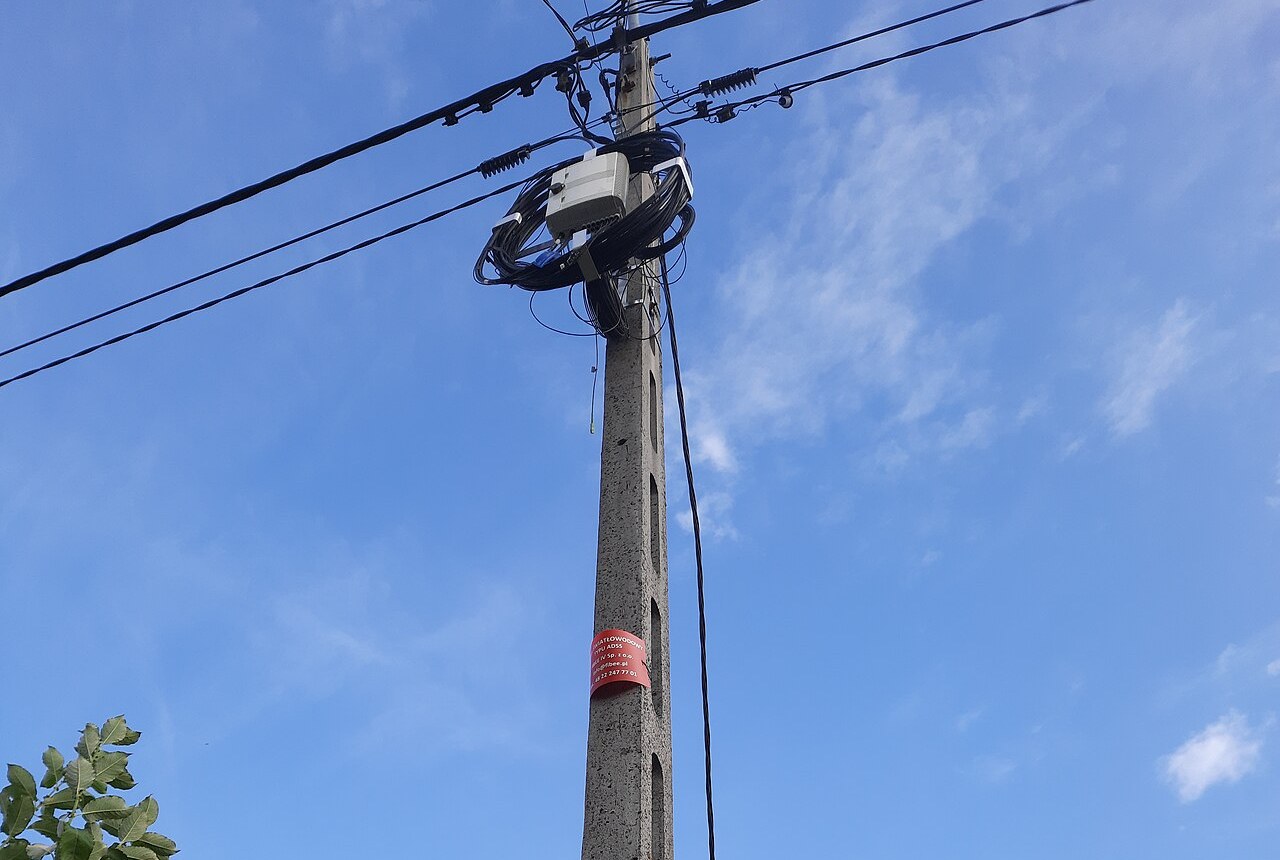 Aerial ADSS fiber optic cable run with service loop on a concrete pole