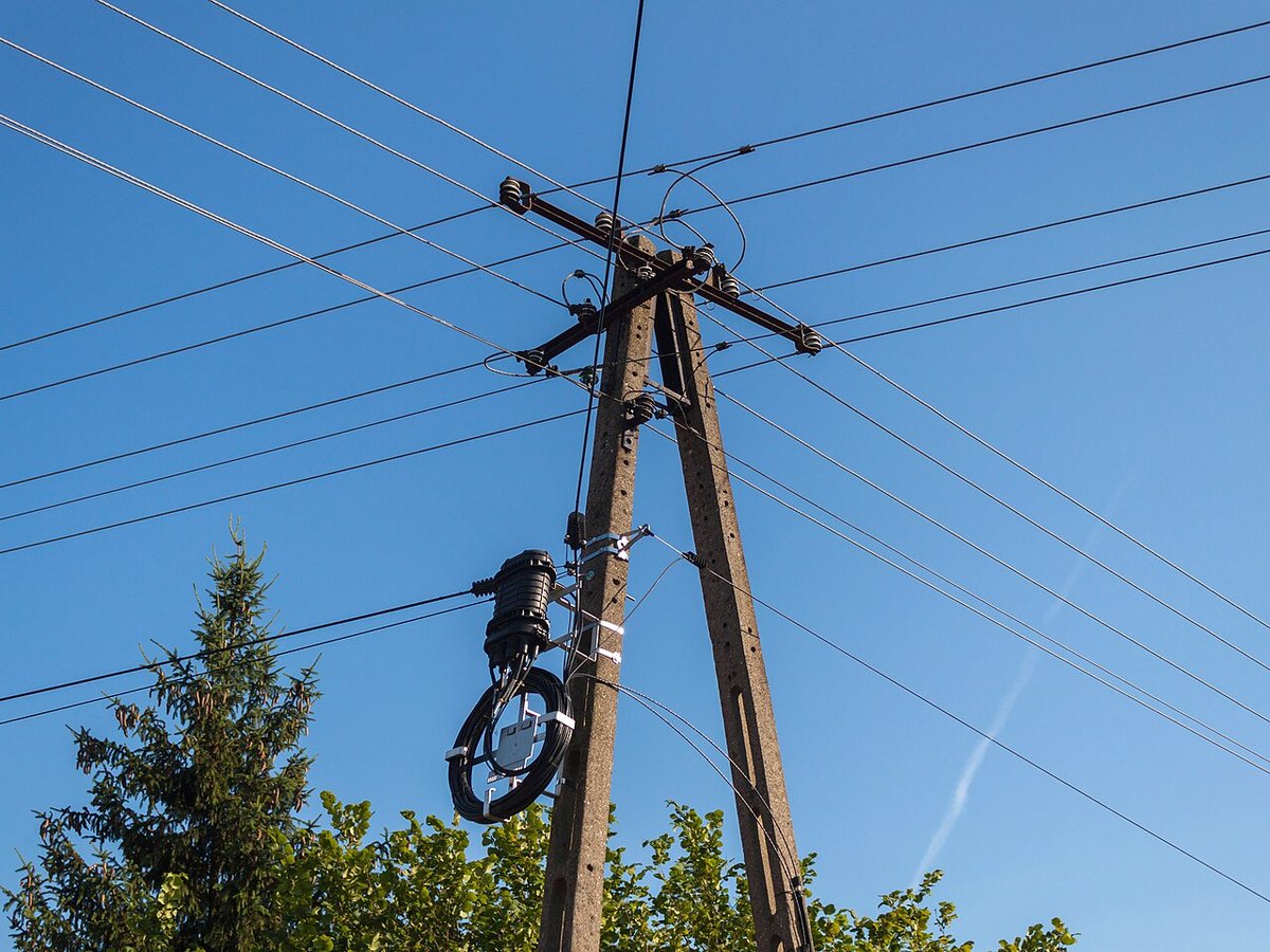 Concrete poles with crossarm fittings, insulators, and aerial fiber closure