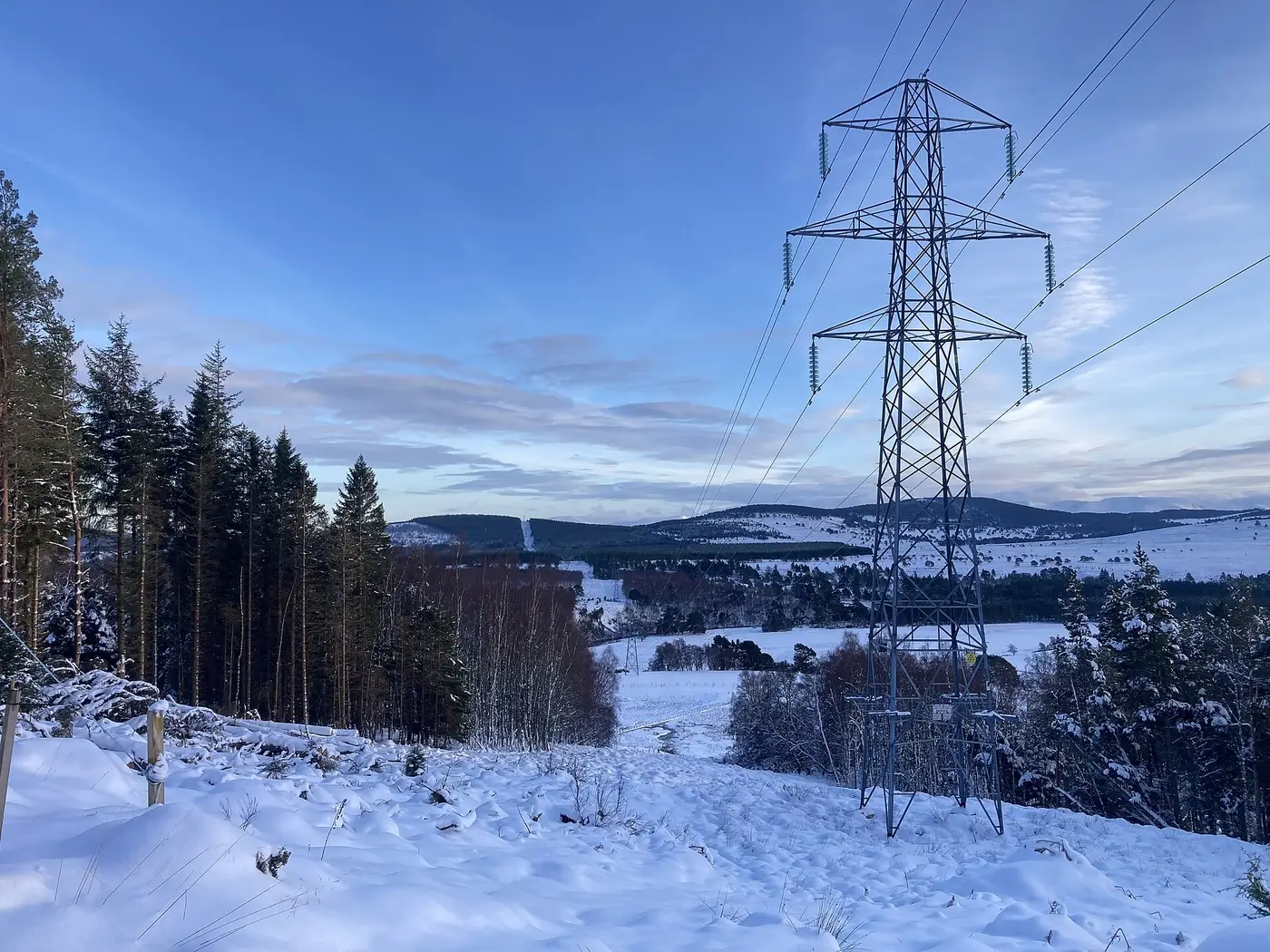 132 kV overhead line with suspension insulator strings crossing snowy highland terrain