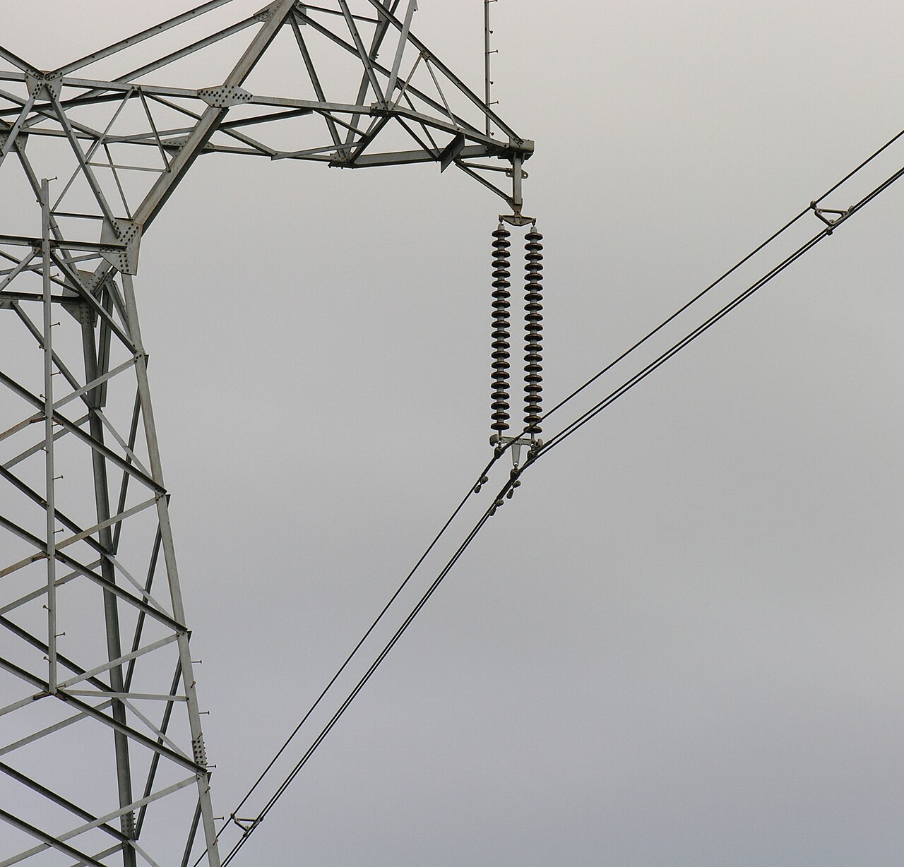 Cap-and-pin porcelain disc strings hung from a transmission tower cross-arm