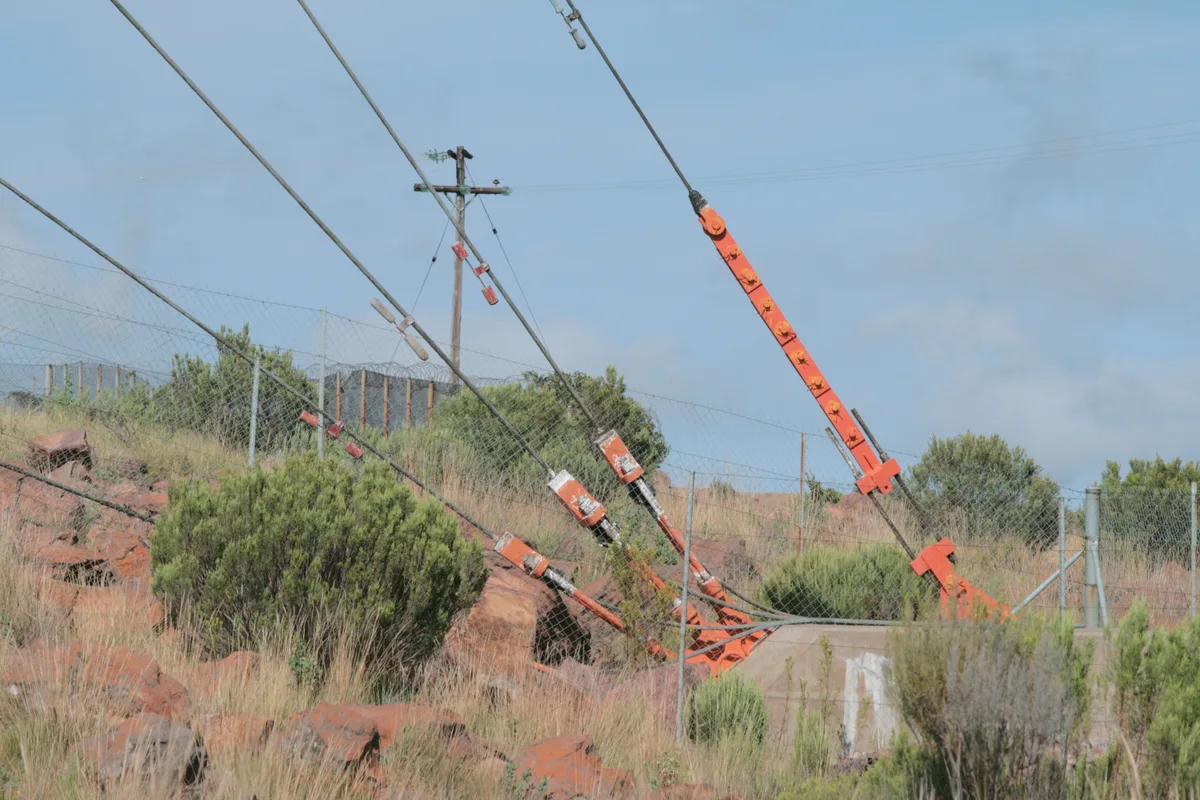 Guy wire running to an earth anchor at the base of a tower