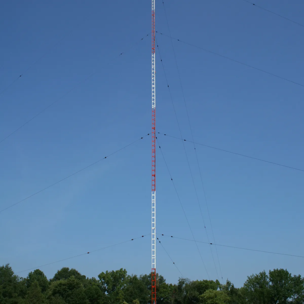Guyed mast structure with guy wires under wind exposure