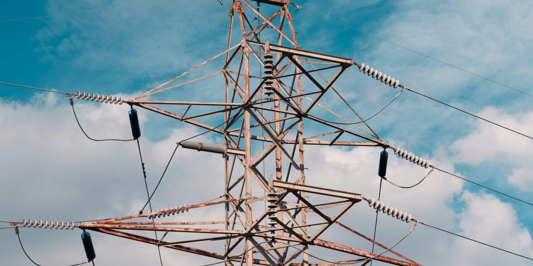 A high voltage power line with a blue sky in the background