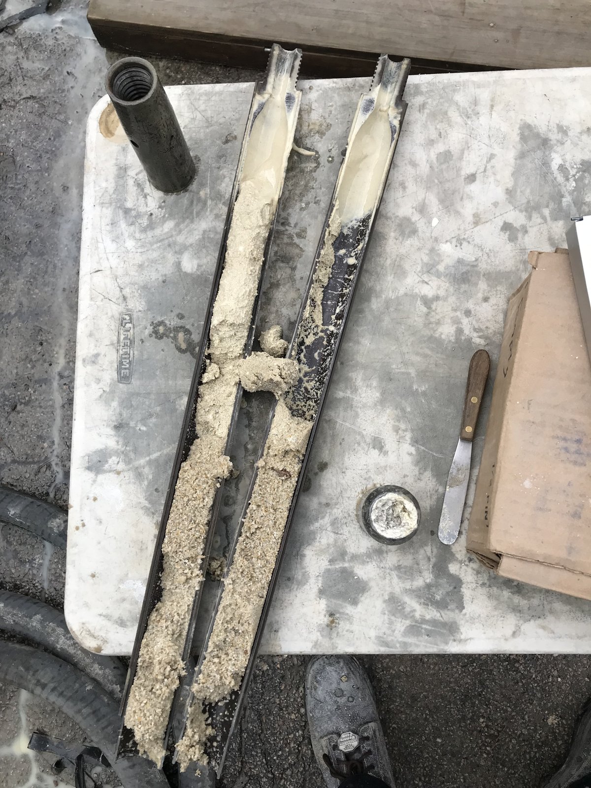 Opened split spoon sampler holding recovered soil core
