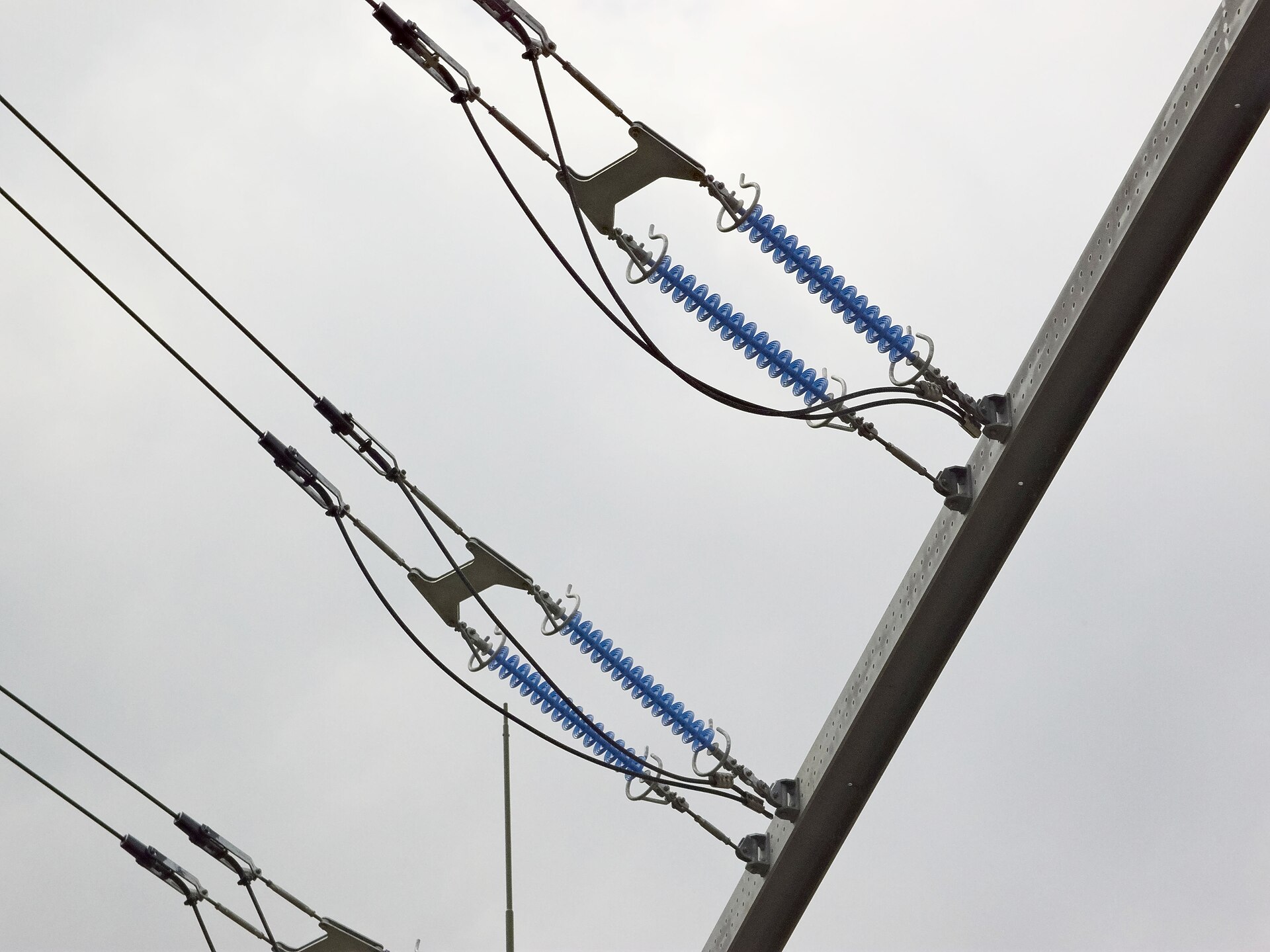 Blue silicone sheds on composite tension insulators at a steel pole