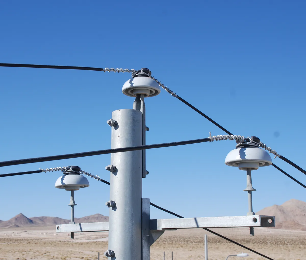 Pin insulators carrying distribution conductors on an overhead line pole