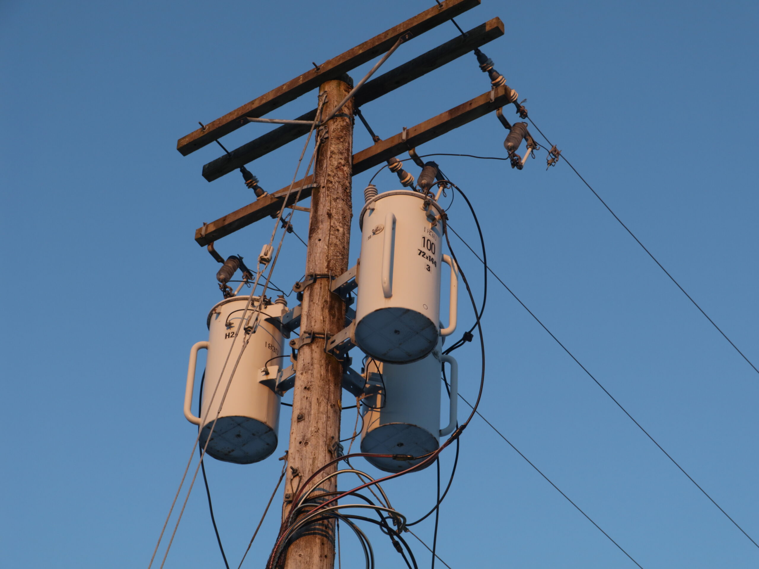 Three-phase wood distribution pole with crossarms and bolted hardware