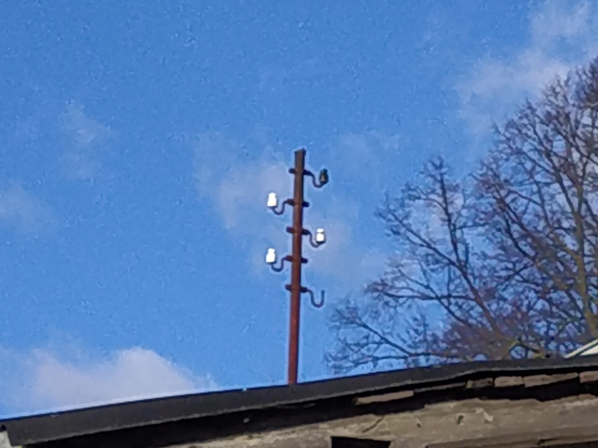 Porcelain pin insulators mounted up a narrow service pole