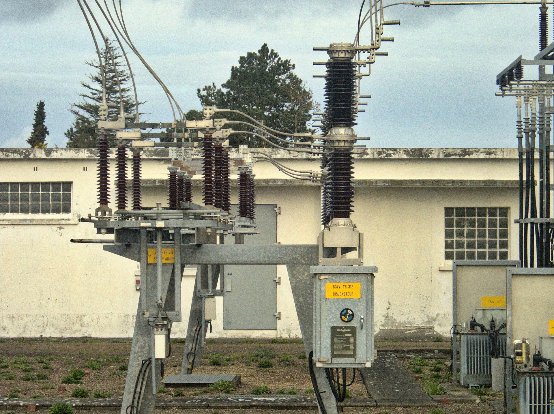 Brown porcelain post insulators supporting equipment and buswork in an outdoor substation bay