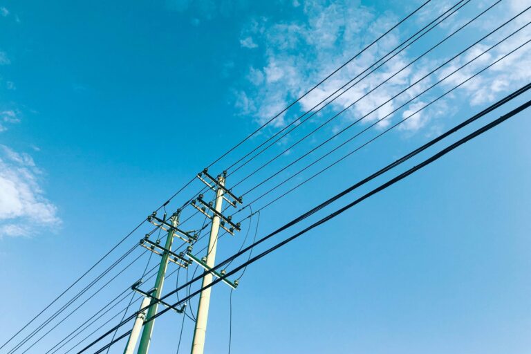 power lines and telephone poles against a blue sky