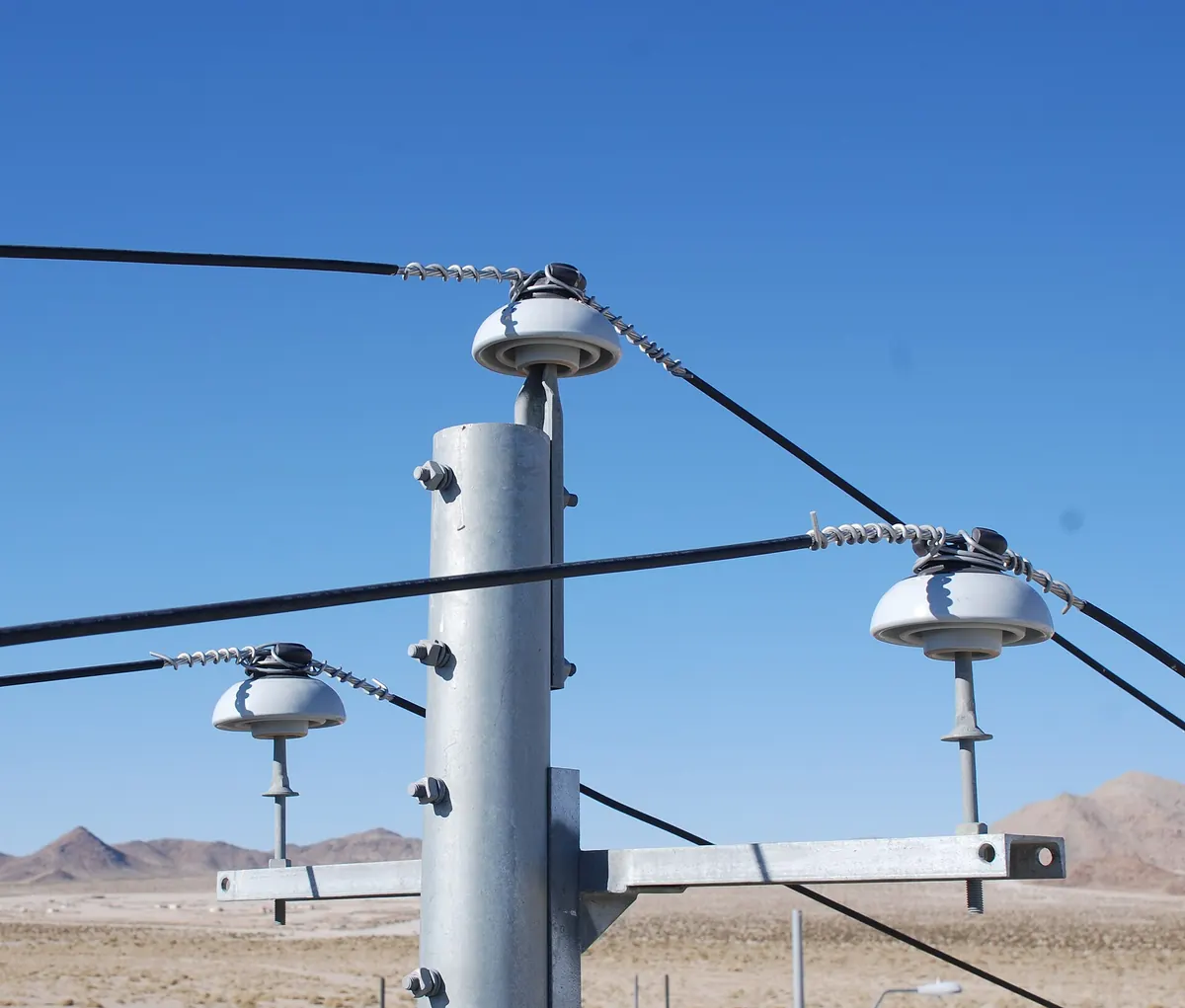 Cross arm with insulators on a galvanized utility pole
