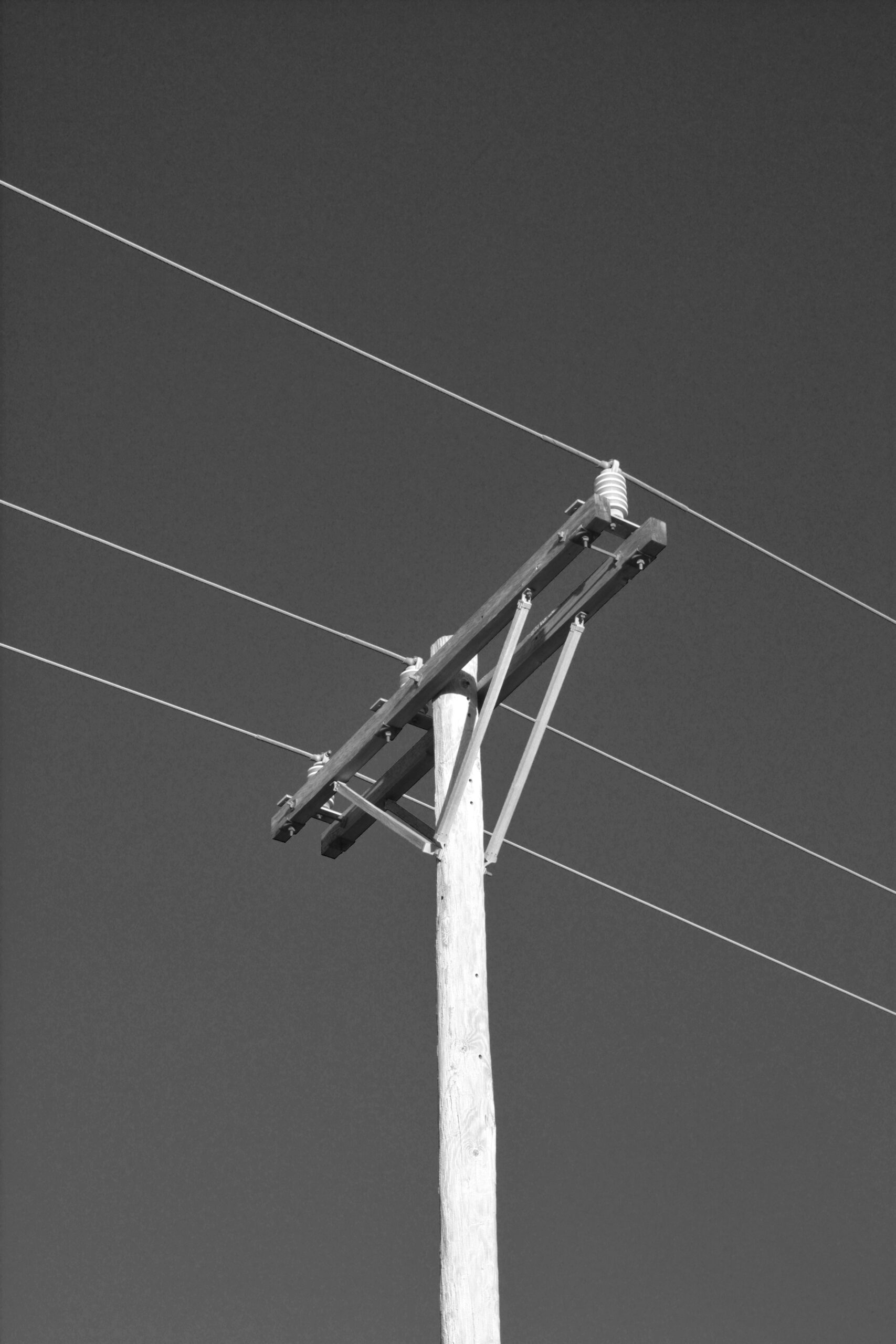 Wooden utility pole with wires against sky